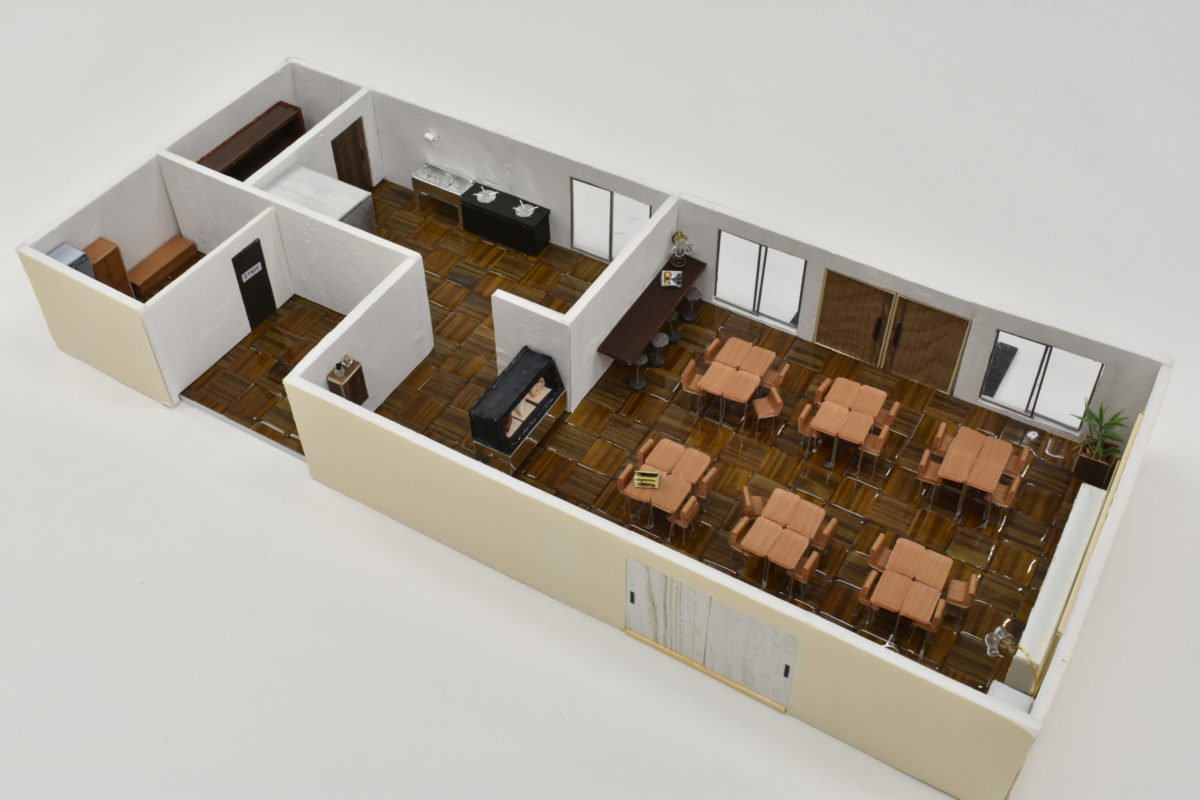 模型全体です。カフェスペース全体のインテリアは、教室の要素を残しています。 厨房やスタッフルームには防災設備や防災用具を収納できるスペースがあります。